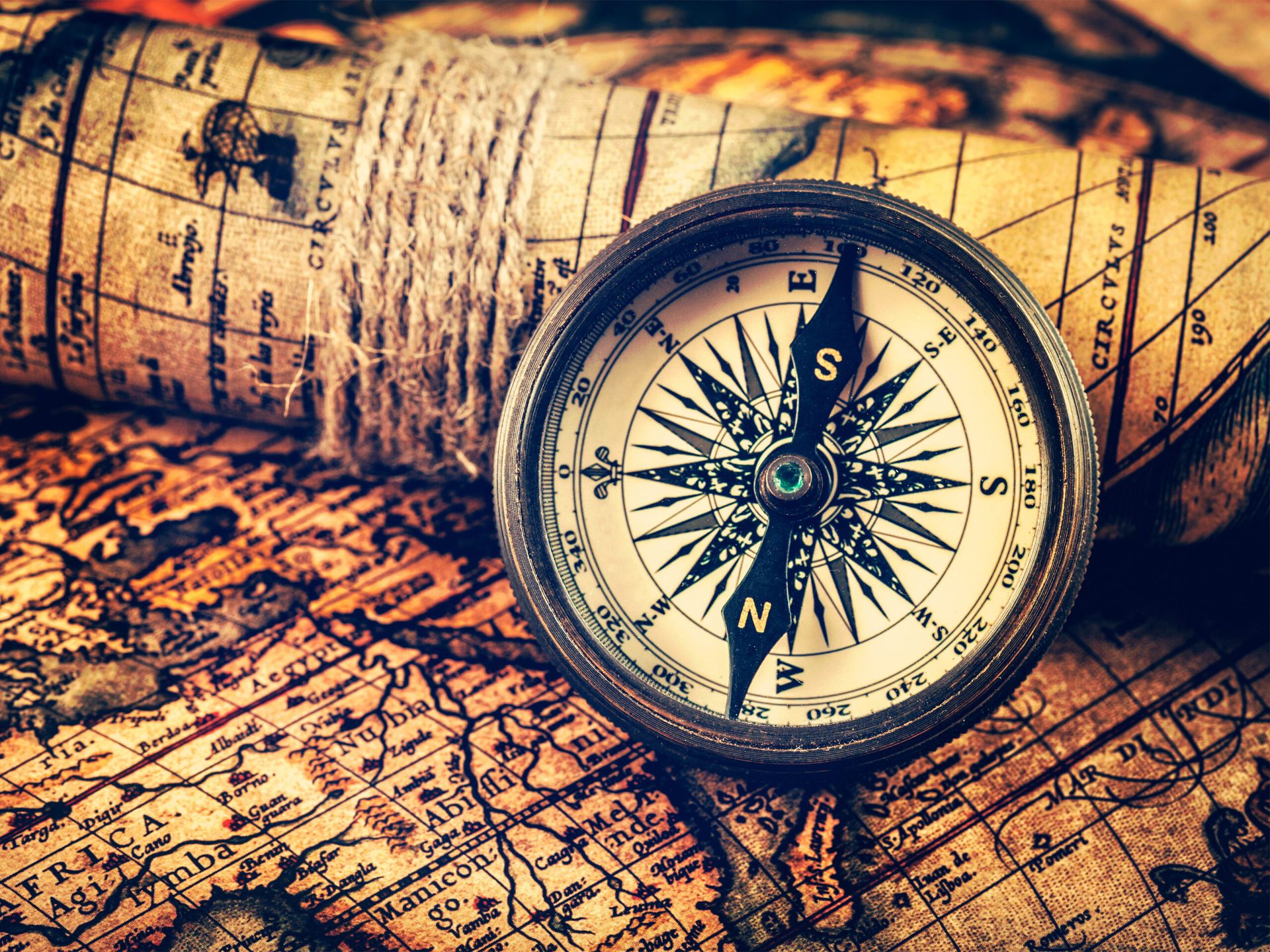 Hipster style image of old vintage retro compass on ancient world map